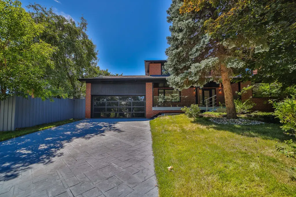 Brick home with a glass garage door and a stamped-concrete driveway — 65 Forest Park Crescent, Thornhill