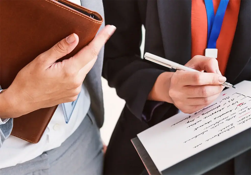 Professionals taking notes and collaborating during a business meeting